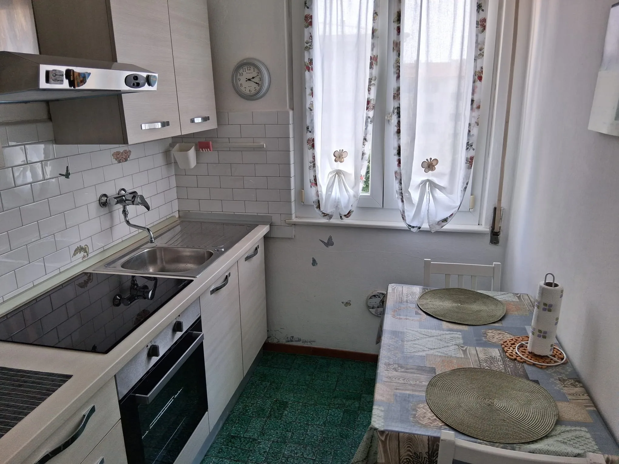 Die separate Küche mit Induktionskochfeld, Backofen und einem Tisch für zwei